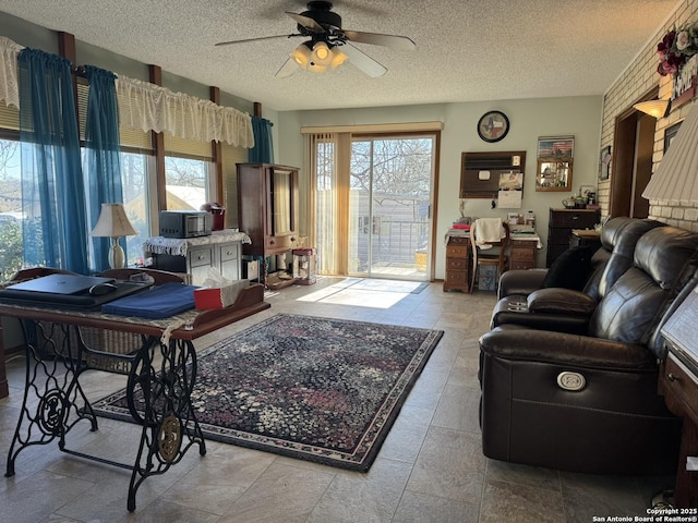 living room featuring a textured ceiling and ceiling fan