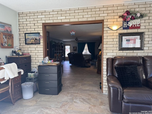 living room with a textured ceiling and ceiling fan