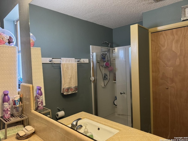 bathroom with sink, a textured ceiling, and walk in shower