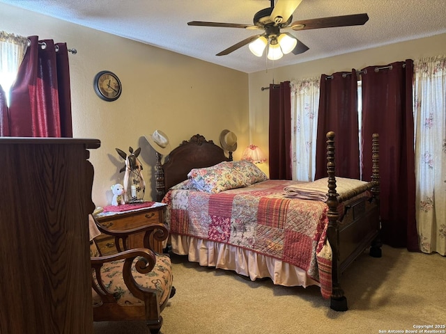 carpeted bedroom featuring a textured ceiling and ceiling fan