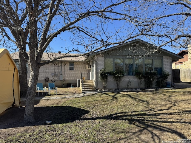 rear view of property featuring a yard