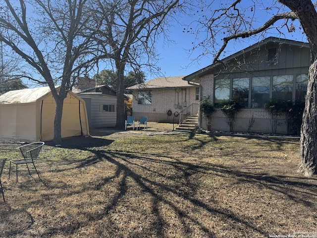 exterior space featuring a storage unit and a yard