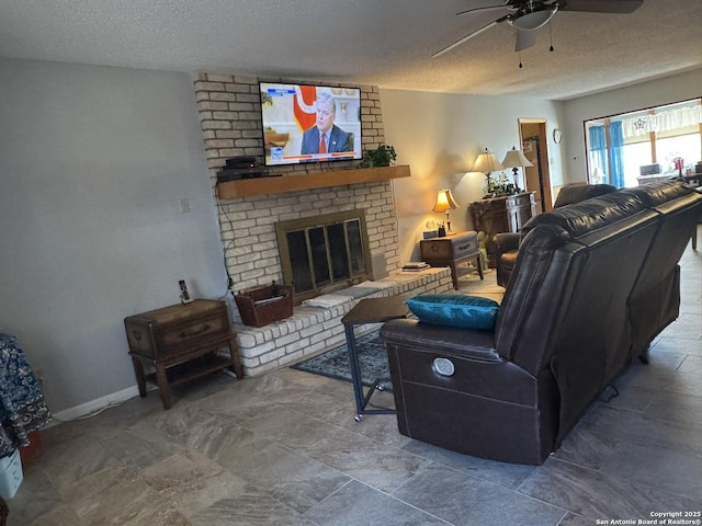 living room with ceiling fan, a fireplace, and a textured ceiling