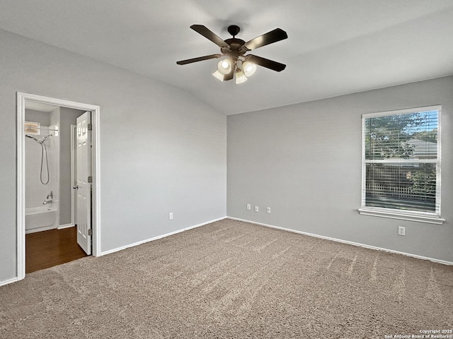 empty room with ceiling fan and dark colored carpet