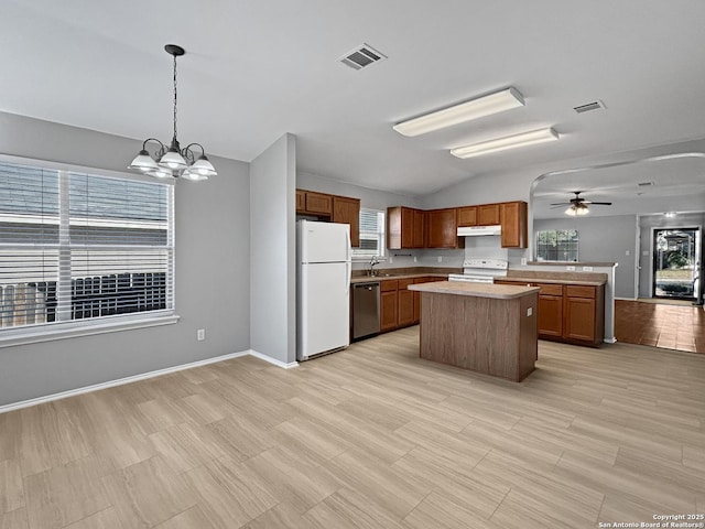 kitchen featuring pendant lighting, sink, white appliances, a kitchen island, and ceiling fan with notable chandelier