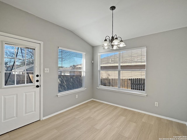 unfurnished dining area featuring an inviting chandelier and vaulted ceiling