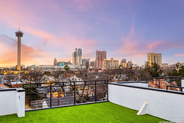 yard at dusk featuring a balcony