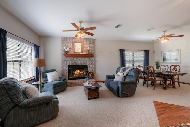 living room featuring a fireplace, plenty of natural light, and carpet flooring