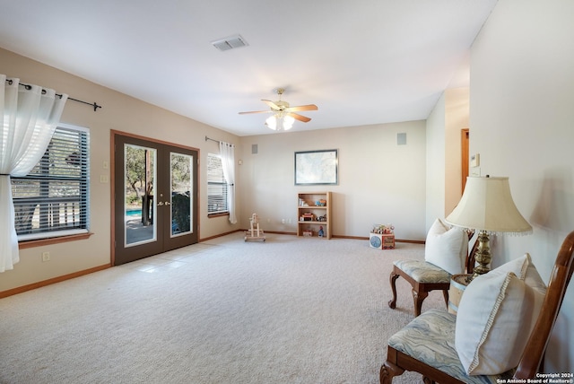 sitting room with light colored carpet, french doors, and ceiling fan