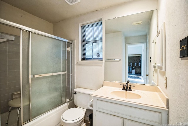 full bathroom featuring shower / bath combination with glass door, vanity, and toilet