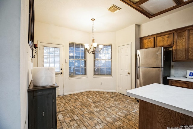 kitchen with stainless steel refrigerator, decorative light fixtures, and an inviting chandelier