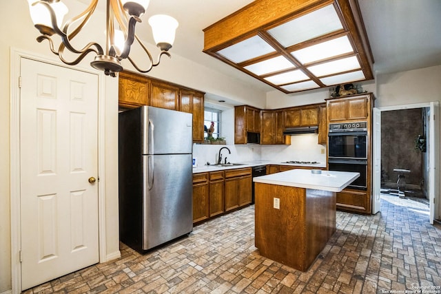 kitchen featuring sink, a center island, hanging light fixtures, white gas stovetop, and stainless steel fridge