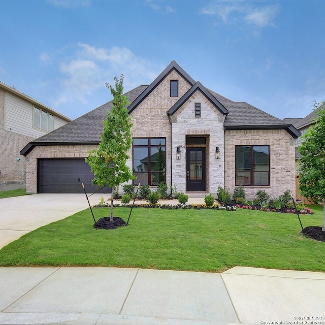 1716 Madden Hvn, San Antonio, TX 78245 - french country home with a shingled roof, an attached garage, driveway, a front yard, and brick siding