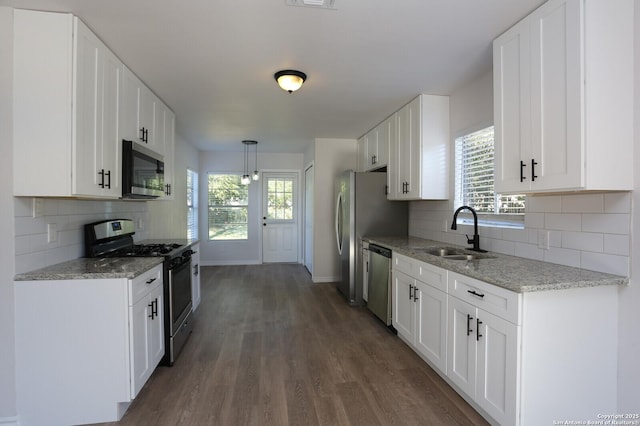 kitchen featuring stainless steel appliances, tasteful backsplash, sink, and white cabinets