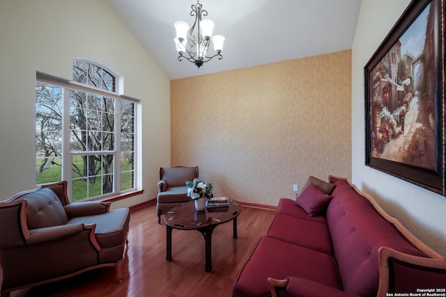 living room featuring lofted ceiling, hardwood / wood-style floors, and a notable chandelier