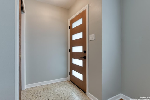 entrance foyer with speckled floor and baseboards