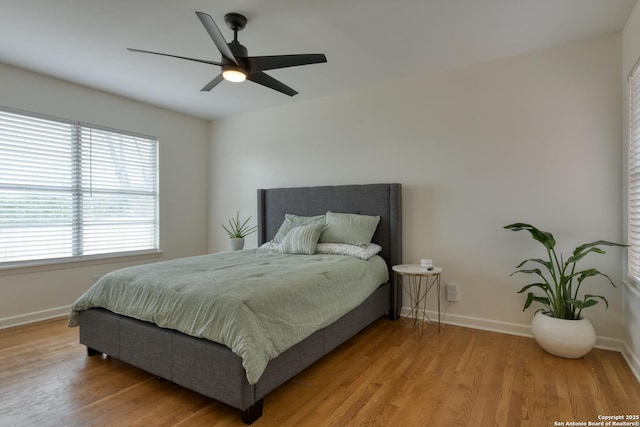 bedroom featuring ceiling fan, baseboards, and wood finished floors