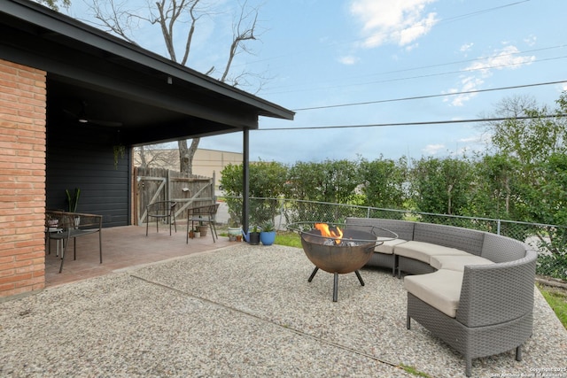 view of patio featuring fence and an outdoor living space with a fire pit