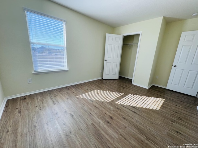 unfurnished bedroom with dark wood-type flooring and a closet