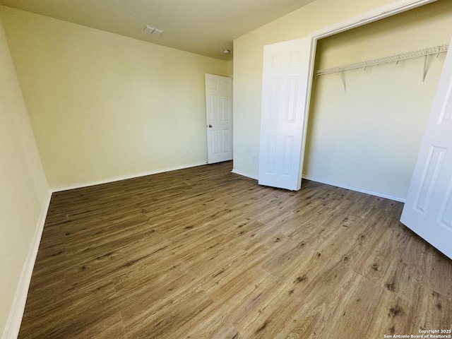 unfurnished bedroom with hardwood / wood-style flooring and a closet