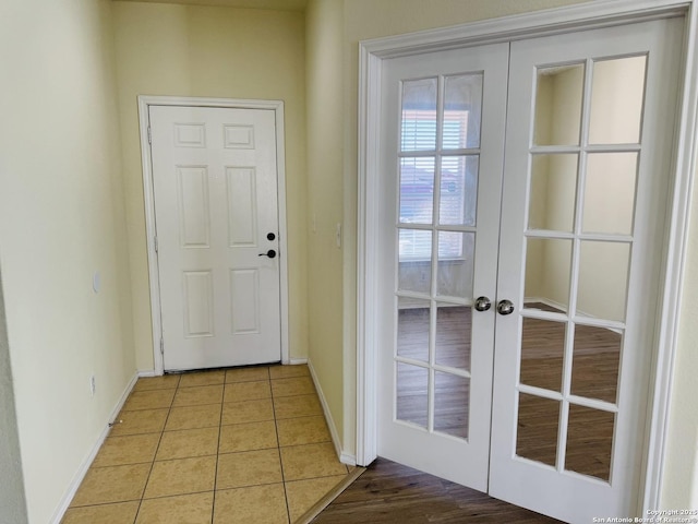 entryway with light tile patterned floors and french doors