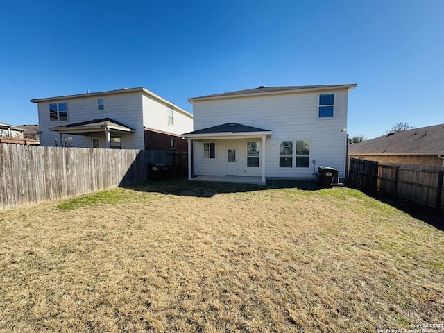 rear view of property with a yard and a patio