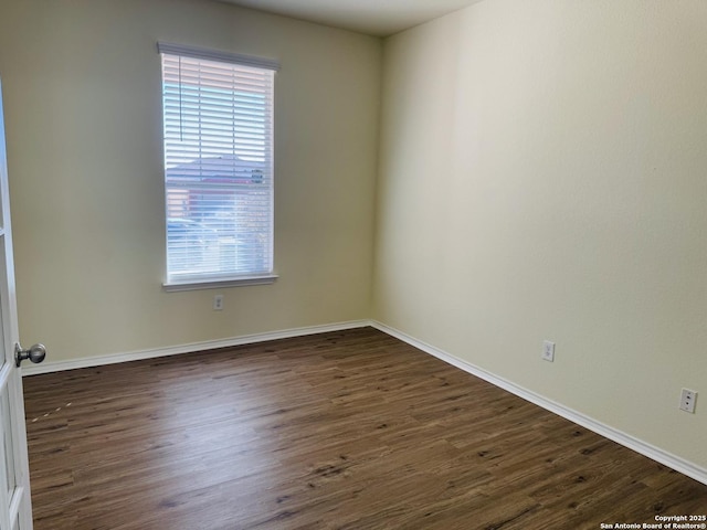 unfurnished room with dark wood-type flooring