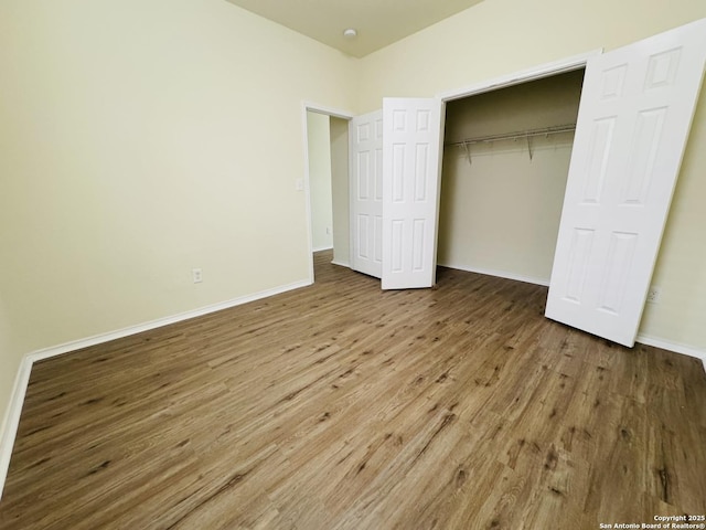 unfurnished bedroom featuring hardwood / wood-style floors and a closet