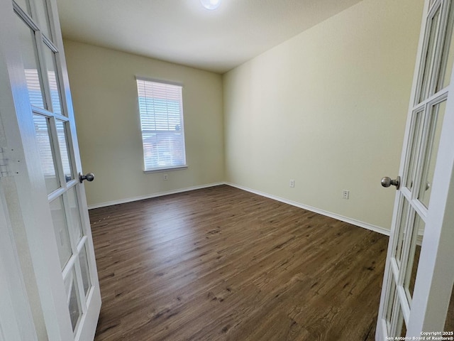 spare room featuring dark hardwood / wood-style flooring and french doors