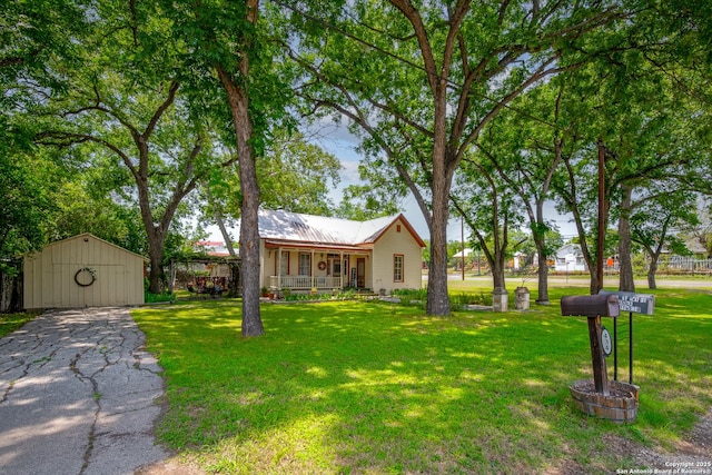 view of front of home with a shed, covered porch, and a front lawn