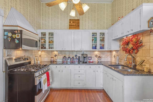 kitchen with appliances with stainless steel finishes, sink, and white cabinets