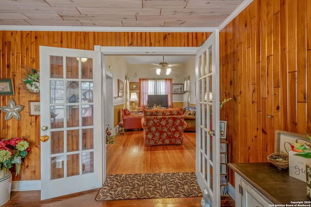 doorway to outside with wood walls, light wood-type flooring, and french doors