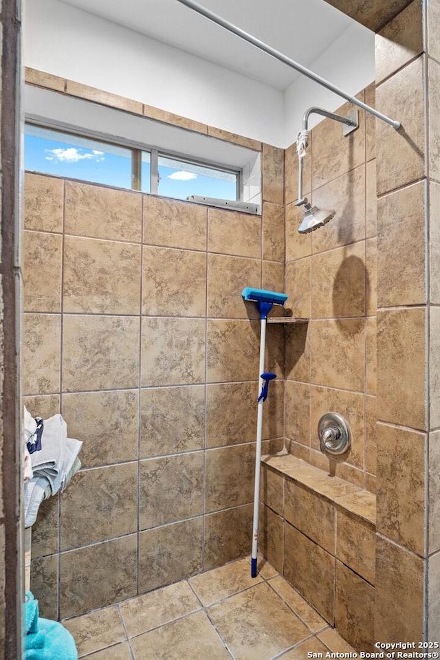 bathroom featuring tiled shower and a wealth of natural light