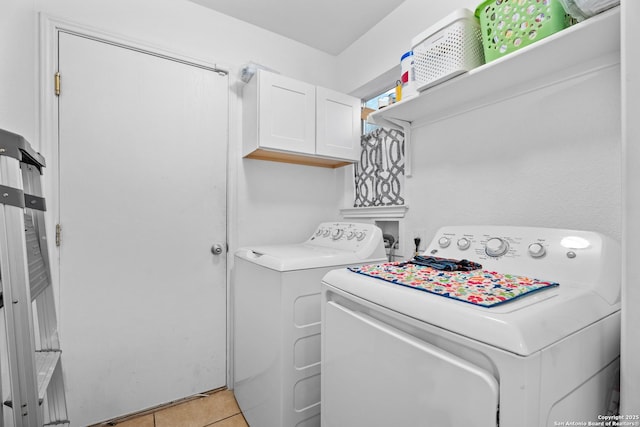 laundry room with cabinets, washer and dryer, and light tile patterned floors