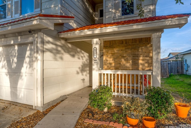 doorway to property featuring a porch and a garage