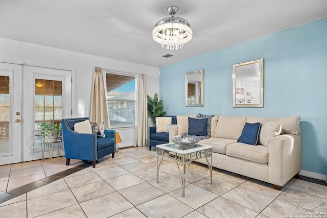 living room with french doors, light tile patterned floors, and a notable chandelier