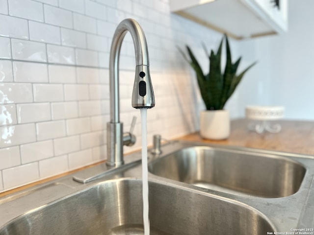 interior details featuring sink and backsplash