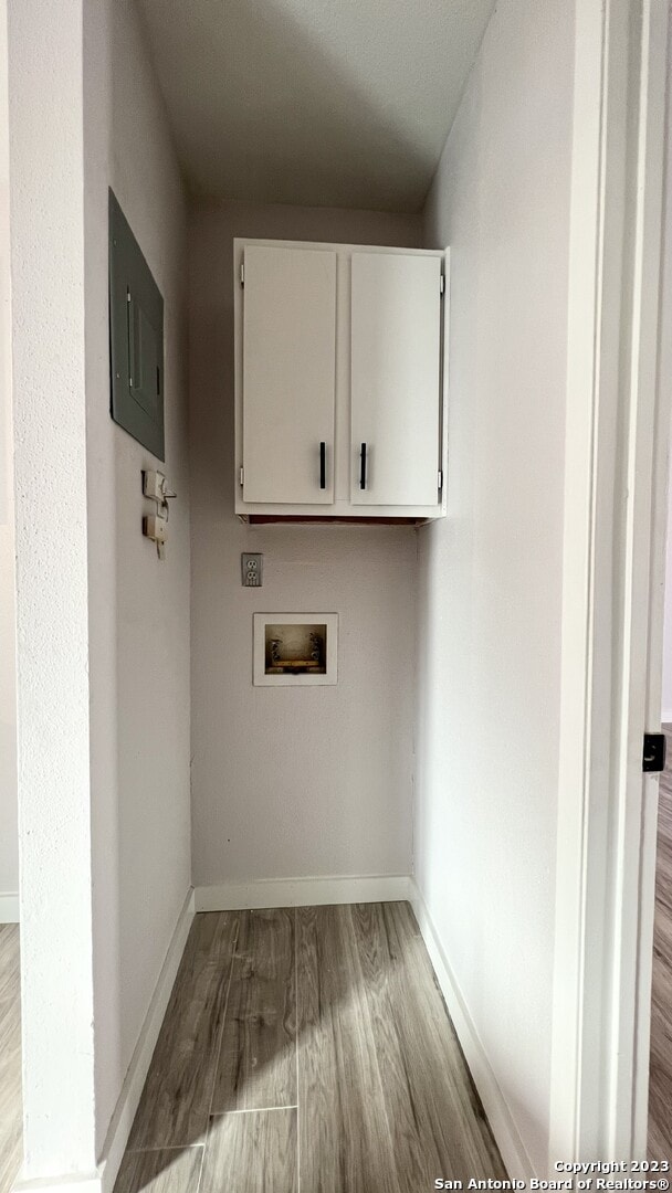 laundry area featuring cabinets, washer hookup, electric panel, and hardwood / wood-style floors