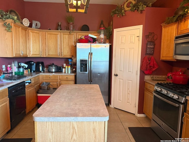 kitchen with appliances with stainless steel finishes, a kitchen island, and light tile patterned floors