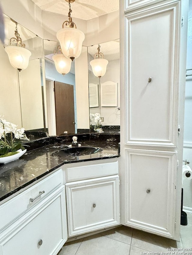 bathroom featuring vanity, tile patterned flooring, and a textured ceiling