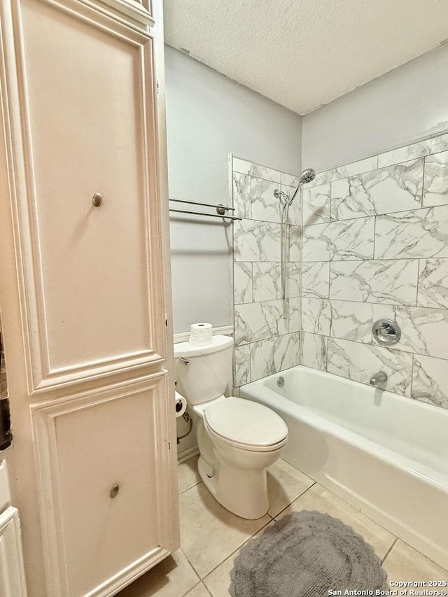 bathroom with toilet, tiled shower / bath combo, tile patterned flooring, and a textured ceiling