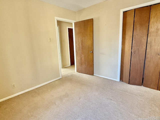 unfurnished bedroom featuring light colored carpet and a closet