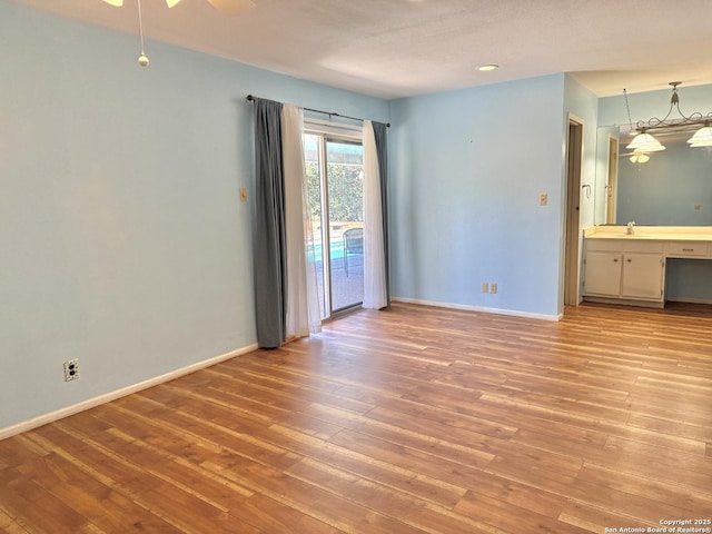 spare room featuring sink and light hardwood / wood-style flooring