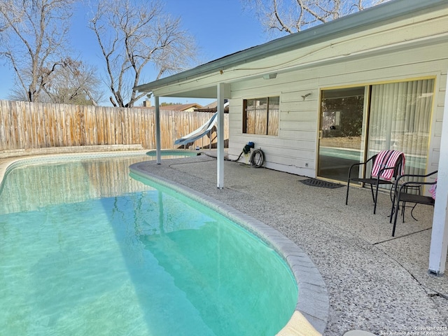 view of pool with a patio area and a water slide