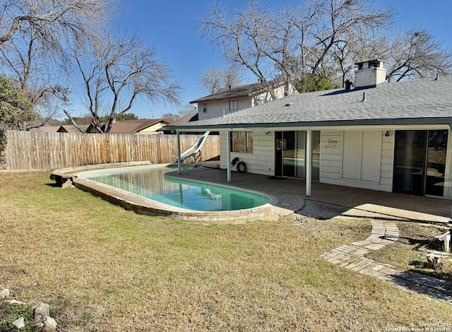 view of swimming pool with a yard, a water slide, and a patio area