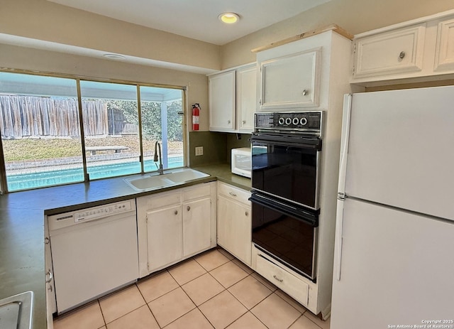 kitchen featuring sink, white appliances, light tile patterned floors, backsplash, and white cabinets