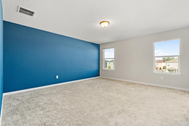 unfurnished room with carpet floors and a textured ceiling