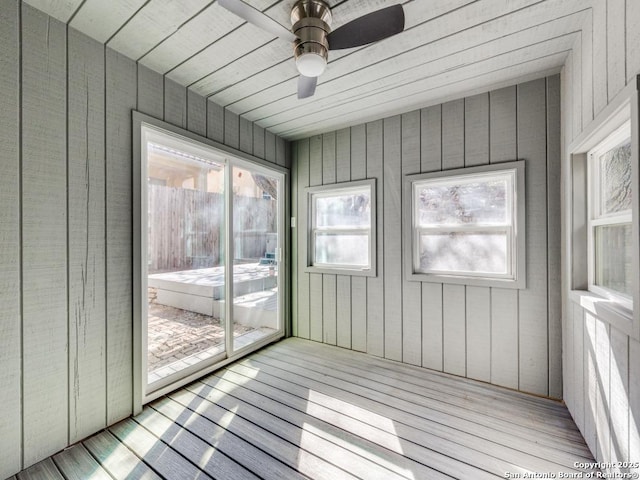 unfurnished sunroom with ceiling fan