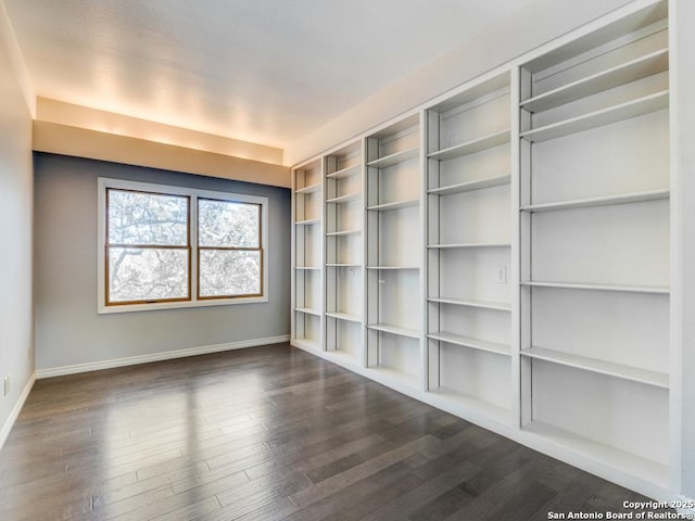 unfurnished room with dark wood-type flooring