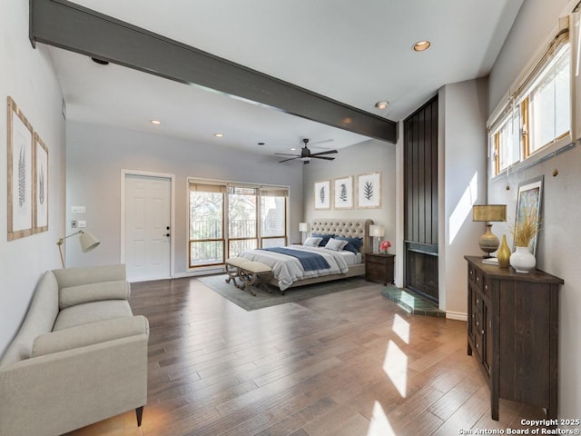 bedroom featuring beam ceiling, wood-type flooring, and ceiling fan